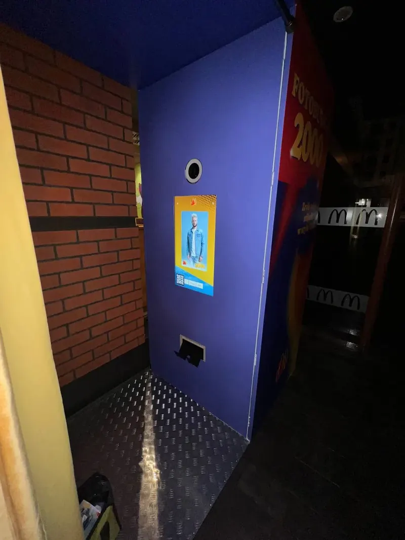 Brandowana Fotobudka AI w stylu Fotobudka 2000 w restauracji McDonald's z motywem ceglanej ściany - wynajem na akcje marketingowe.